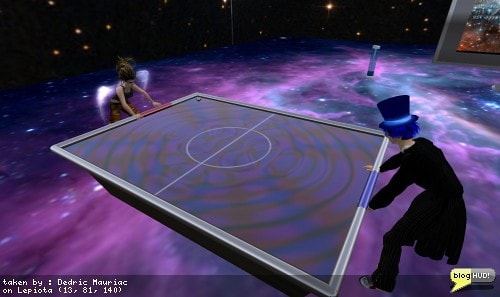 After blogging about my endeavers in a game of Pong, Fae Dama asked me to come on over to her place and check out a game that she had setup. Talia Takogawa joined me for a game one on one and kicked my blue butt to next year. The game plays just like pong. Each player sits on a bar and presses the left and right keys to move the bar back and forth. A silver ball rolls around on the table and bounces off the bars. From Dedric Mauriac via bloghud.com