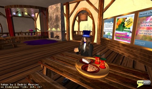 The Elderglen infohub has it's own region in the center of it's community. There are a few things that are really oriented towards a community. The first is having a stage available (although small) that can allow live performances to carry on. It would have been preferable if the instruments could be derezzed for live performers, and instructions provided to allow community members to change the music stream. I half-expected the Linden Radio to be playing, but found that there wasn't any media playing. In another corner of the room, I found a few remnants of a Linden telehub with informative posters about video tutorials, bug reporting, and general information. Another corner had your classic sandbox signs posting rules about violence, commerce, mature behavior, and griefing with audio. The last corner contained a nice bar with free fantasy drinks. A room on one side lead to a large kitchen to grab items (apples and oranges) or to do some work (scrub floors, kn! ead dough). The room on the other end was an alchemists workshop with books, potions, candles, powders and more. It also had a game to catch faries. The region itself had supporting buildings such as a forge, wizards tower, grave yard, and ancient ruins. Each type of resident home was also on this region fully funished. From Dedric Mauriac via bloghud.com